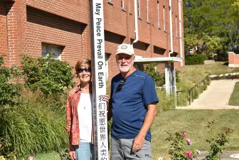 John Lersch ’79 (right) poses with the Peace Pole