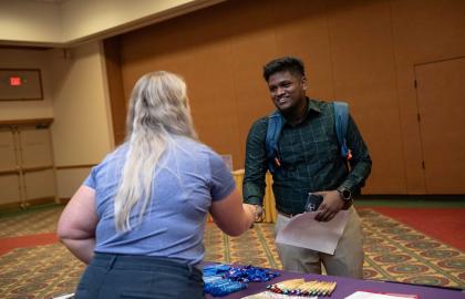 Student shaking hands with recruiter at job fair