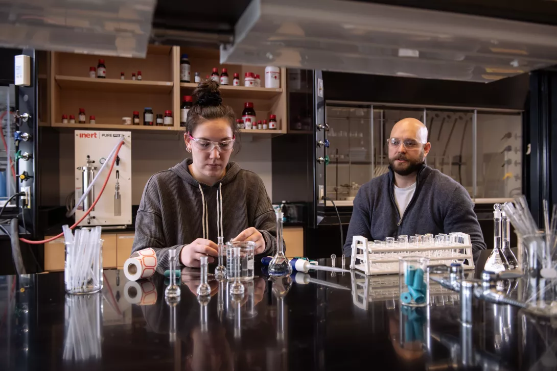 Chemistry professor oversees lab experiment by student