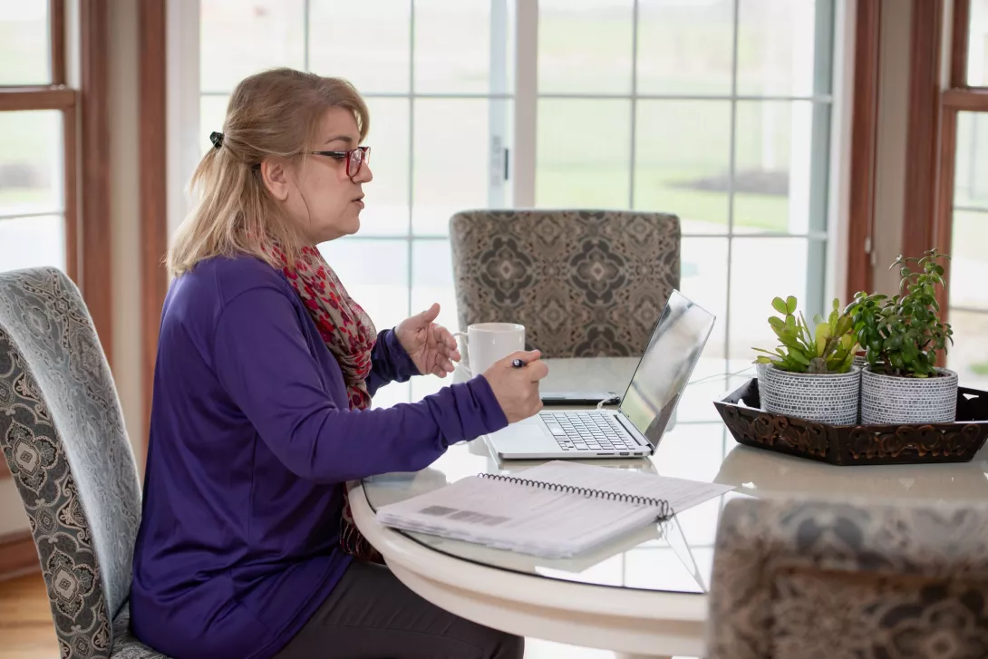 Photo of woman on a computer at home