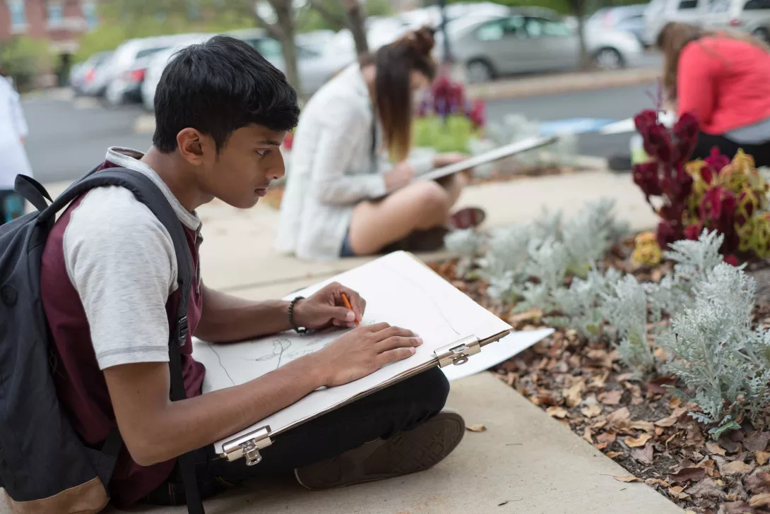 Student in drawing class sitting outside