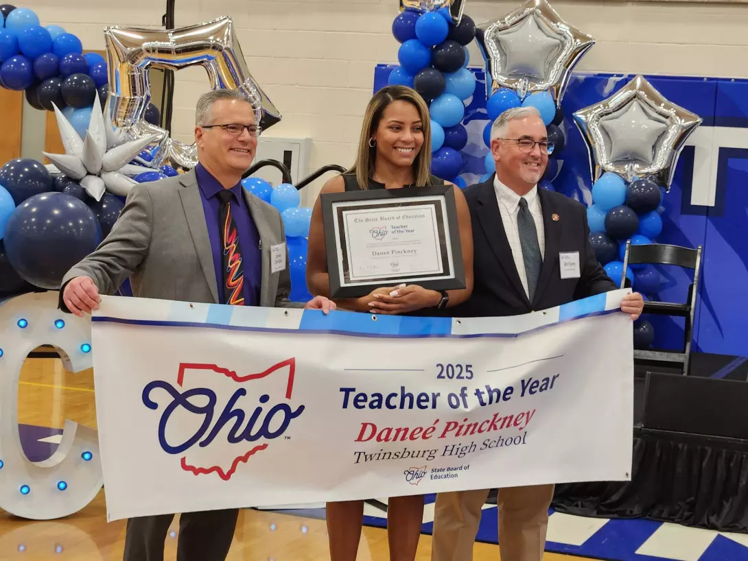 Danee Pinckney with plaque and banner